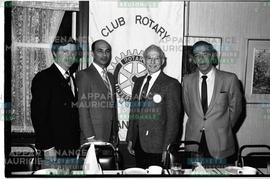 Hommes devant bannière du club Rotary