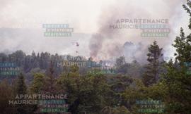 Hélicoptère survolant une forêt en feu