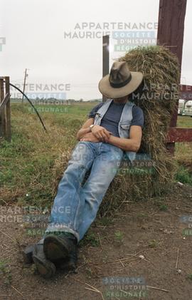 Personne couchée sur une botte de foin
