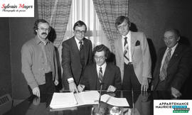 Personnes se tenant en groupe pour la signature d'entente de Woolworth