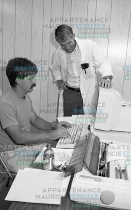 Deux hommes devant un ordinateur
