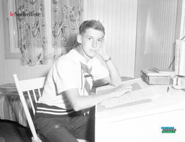 001 - Jeune homme assis à un bureau