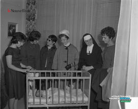 003 - Bébé dans son berceau et femmes