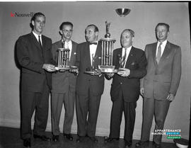 001 - Groupe d'hommes debout tenant deux trophées