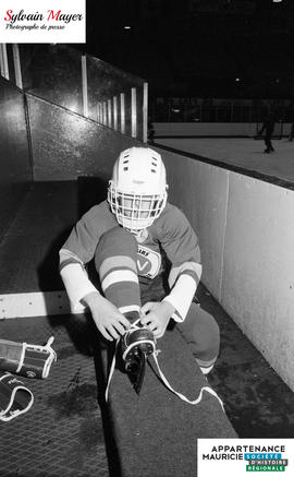 Joueur attachant son patin